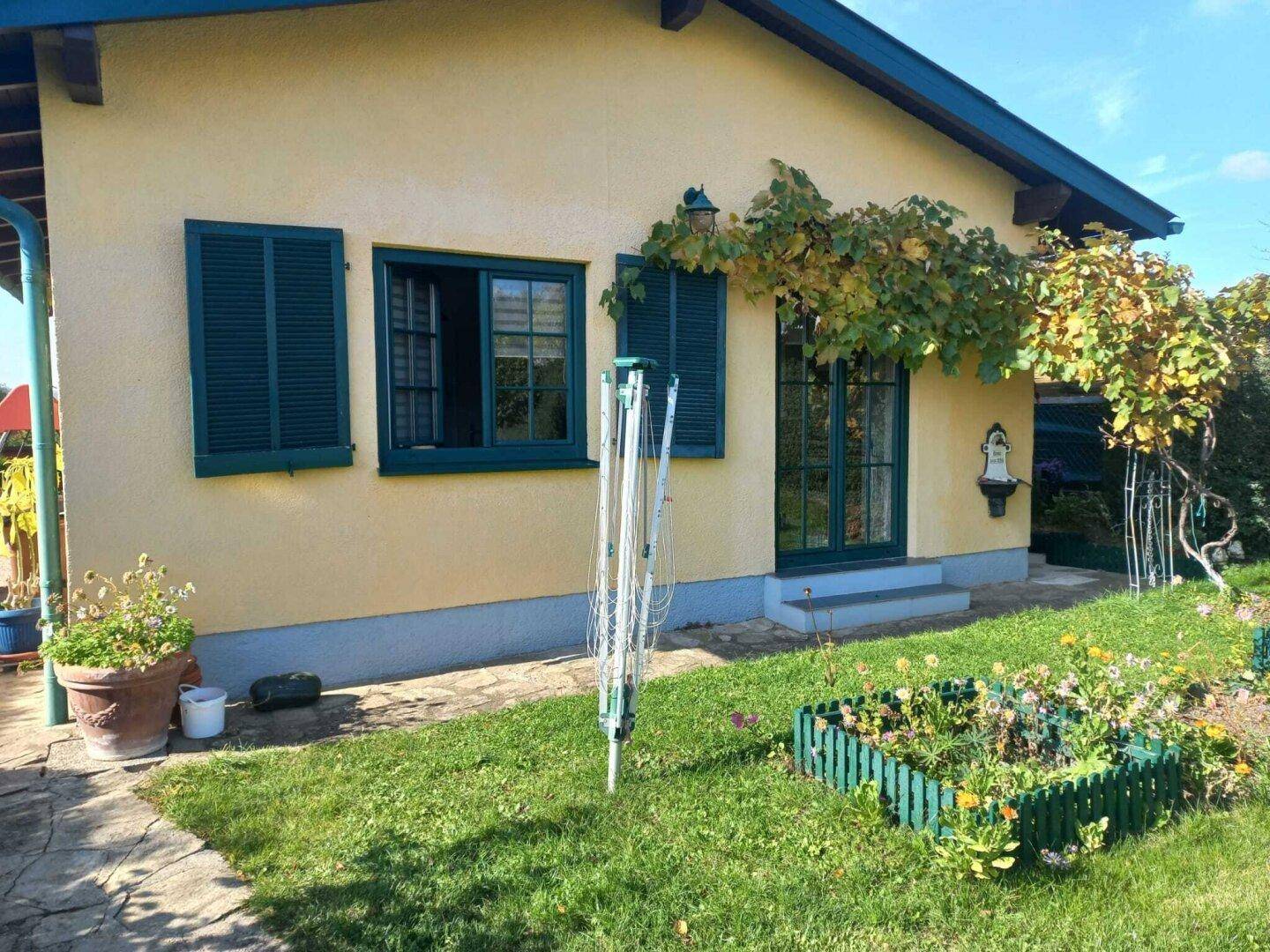 Seitlicher Gartenbereich des Hauses mit Wäscheleine und einem kleinen Blumenbeet.