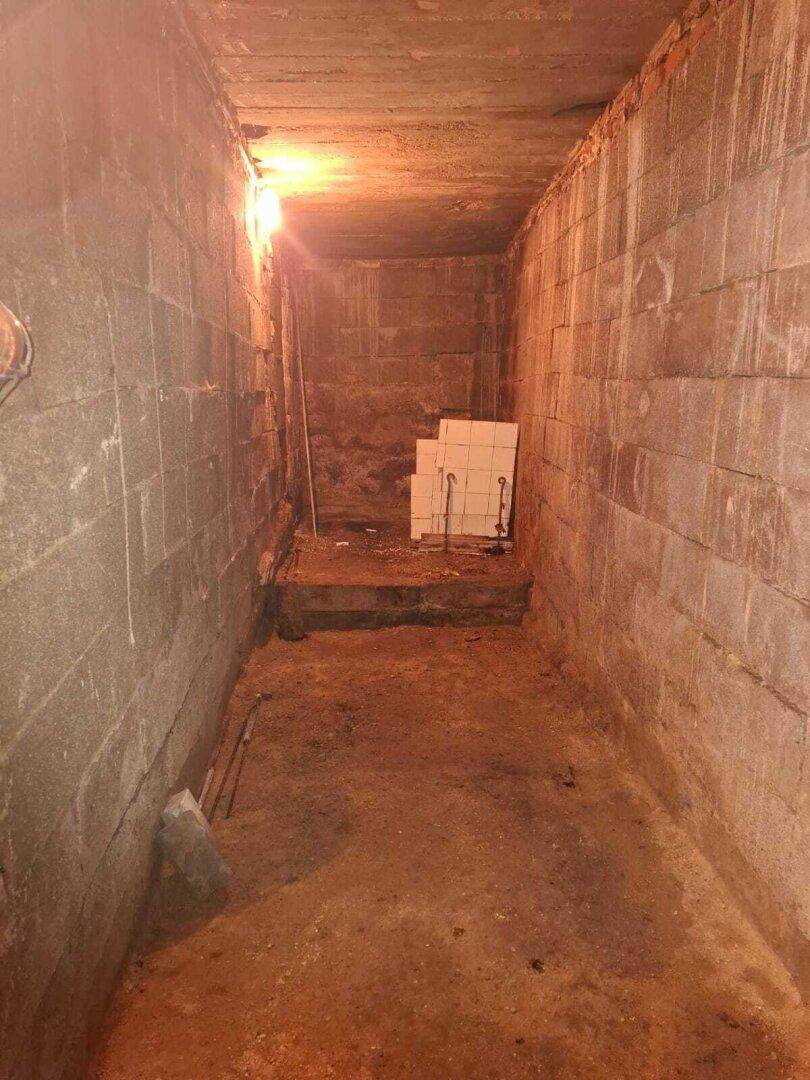 Unausgebauter Kellerraum mit Ziegelwänden und einem Erdboden, der viel Potenzial bietet.