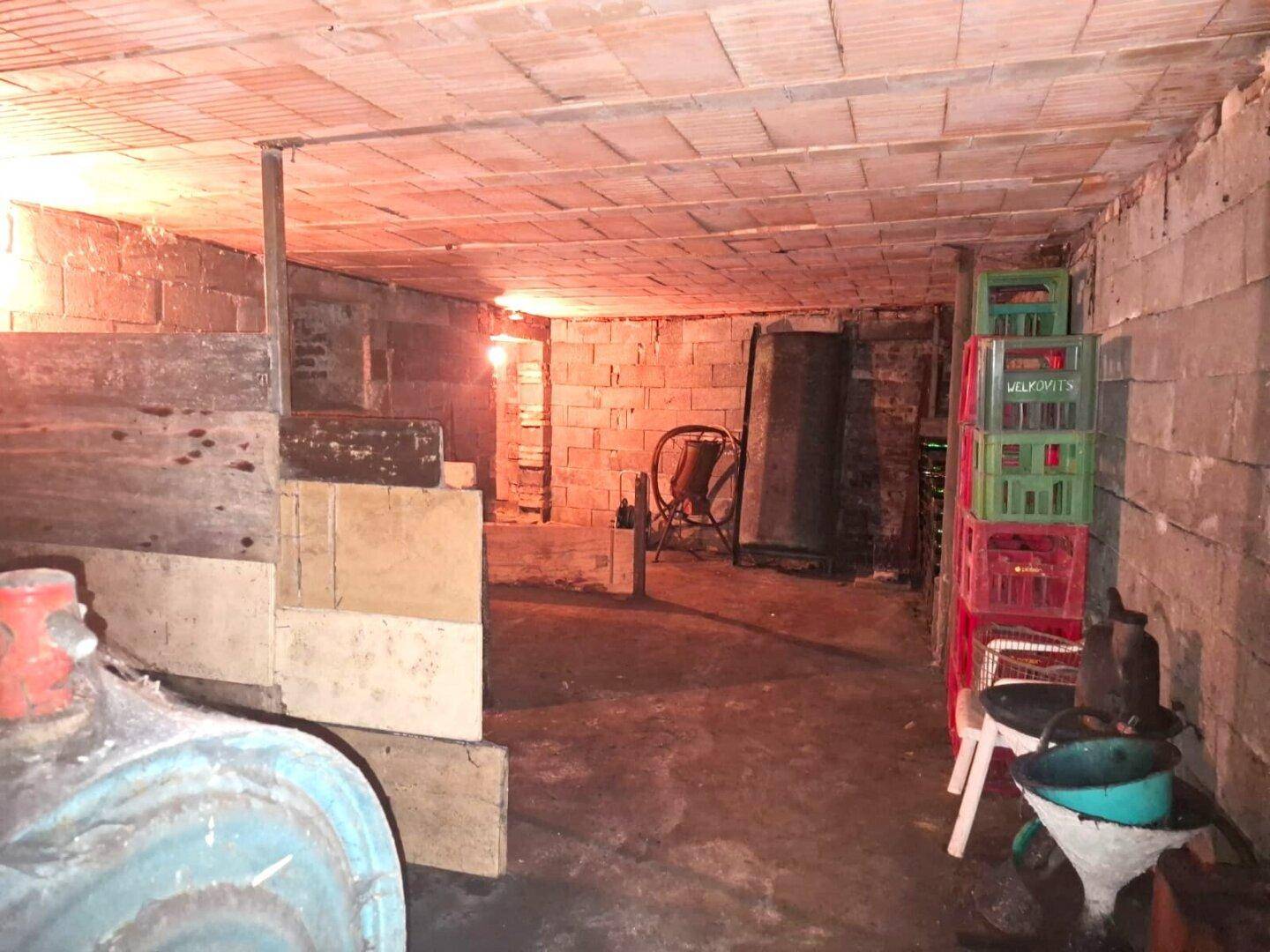 Geräumiger Kellerraum mit Ziegelwänden und verschiedenen gelagerten Gegenständen, ideal als Lagerfläche.