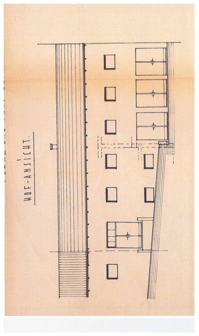 Architektonische Hofansicht eines Gebäudes mit Fensterreihen und einem schrägen Dach.