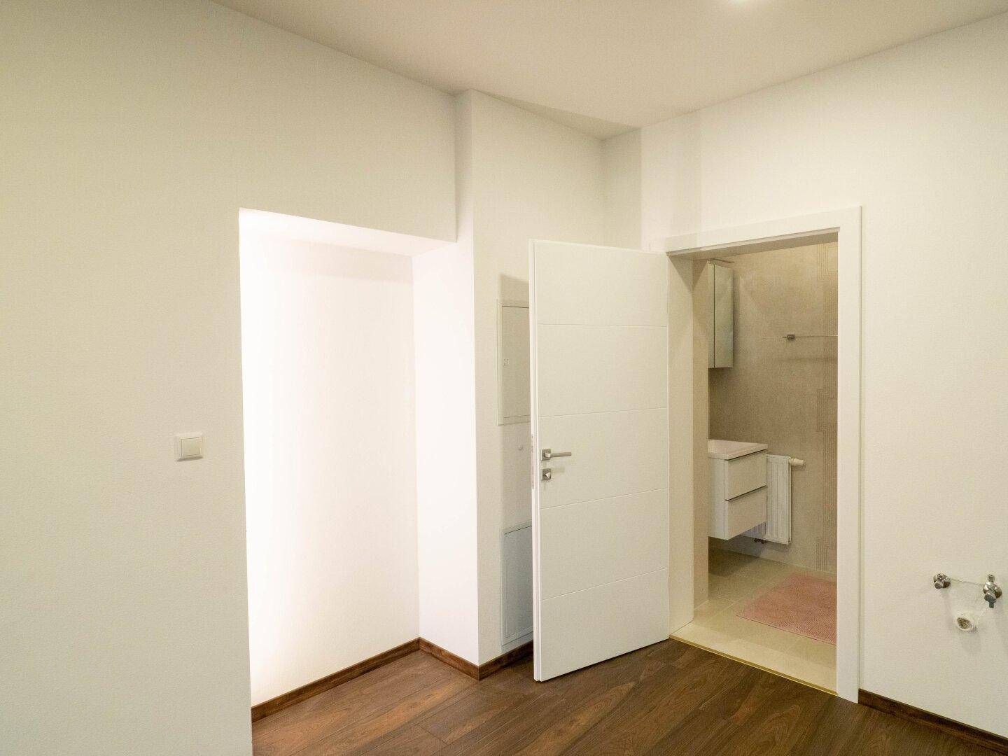 Eingangsbereich mit Zugang zu einem Badezimmer und einer praktischen Nische.