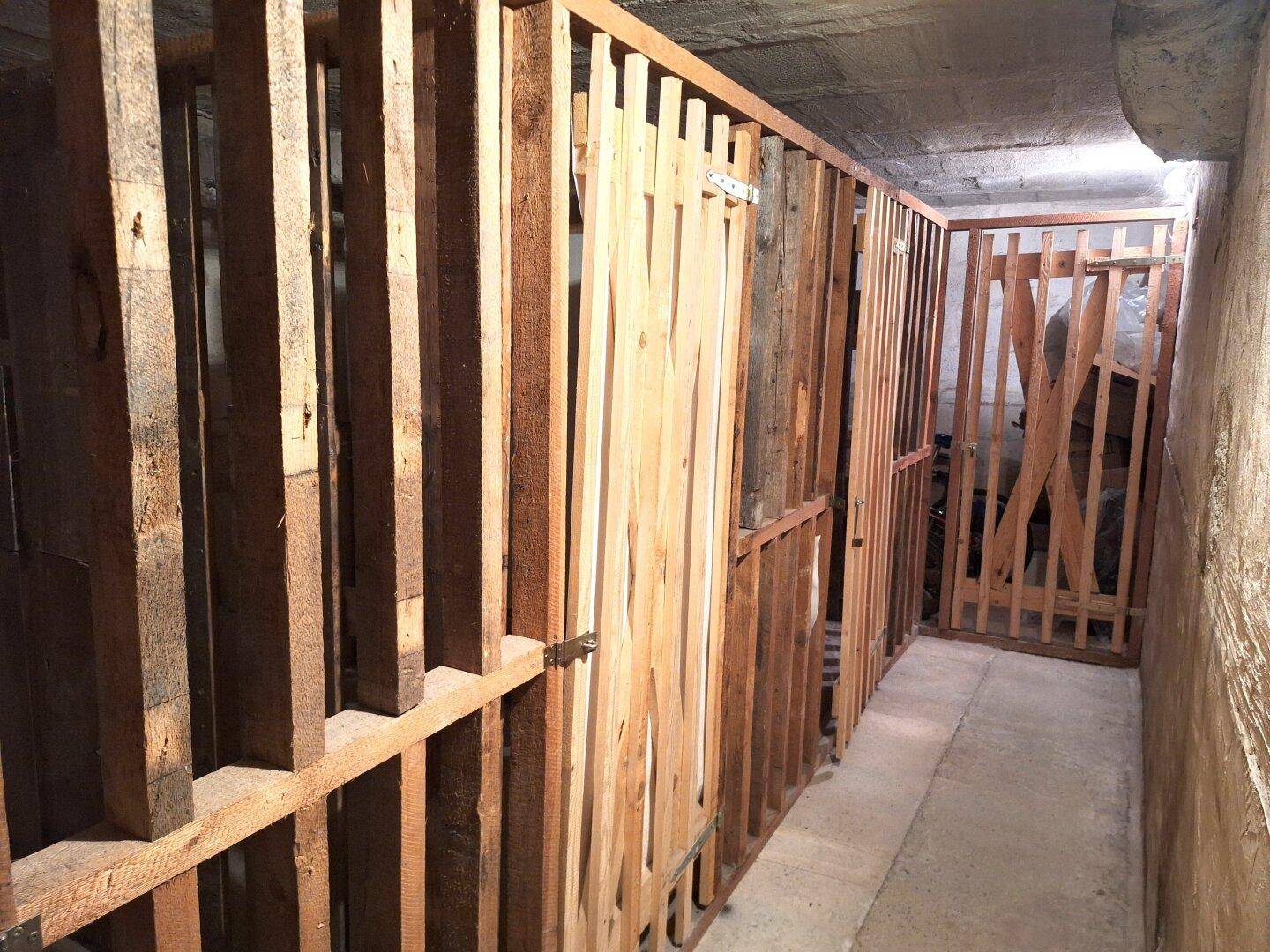 Kellerabteile mit Holzlattenwänden für zusätzlichen Stauraum.