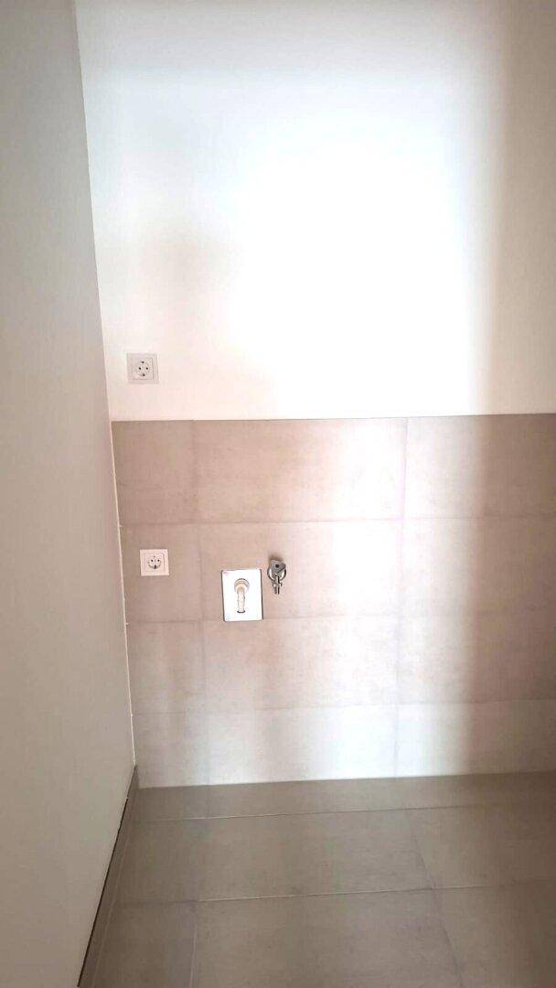 Wandbereich mit Fliesen und Anschlüssen, möglicherweise für Waschmaschine oder Küchengeräte vorgesehen.