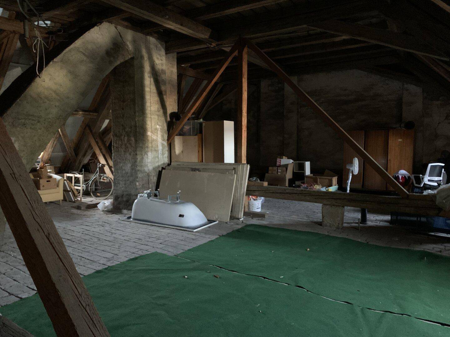 Geräumiger, unfertiger Dachboden mit Holzbalken und Lagerflächen, bereit für den Ausbau.
