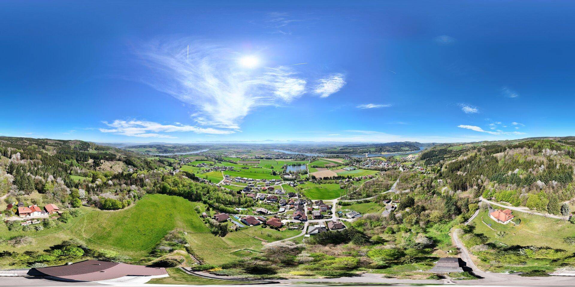 Panoramablick aus der Vogelperspektive auf die ländliche Umgebung mit Häusern und viel Grün.