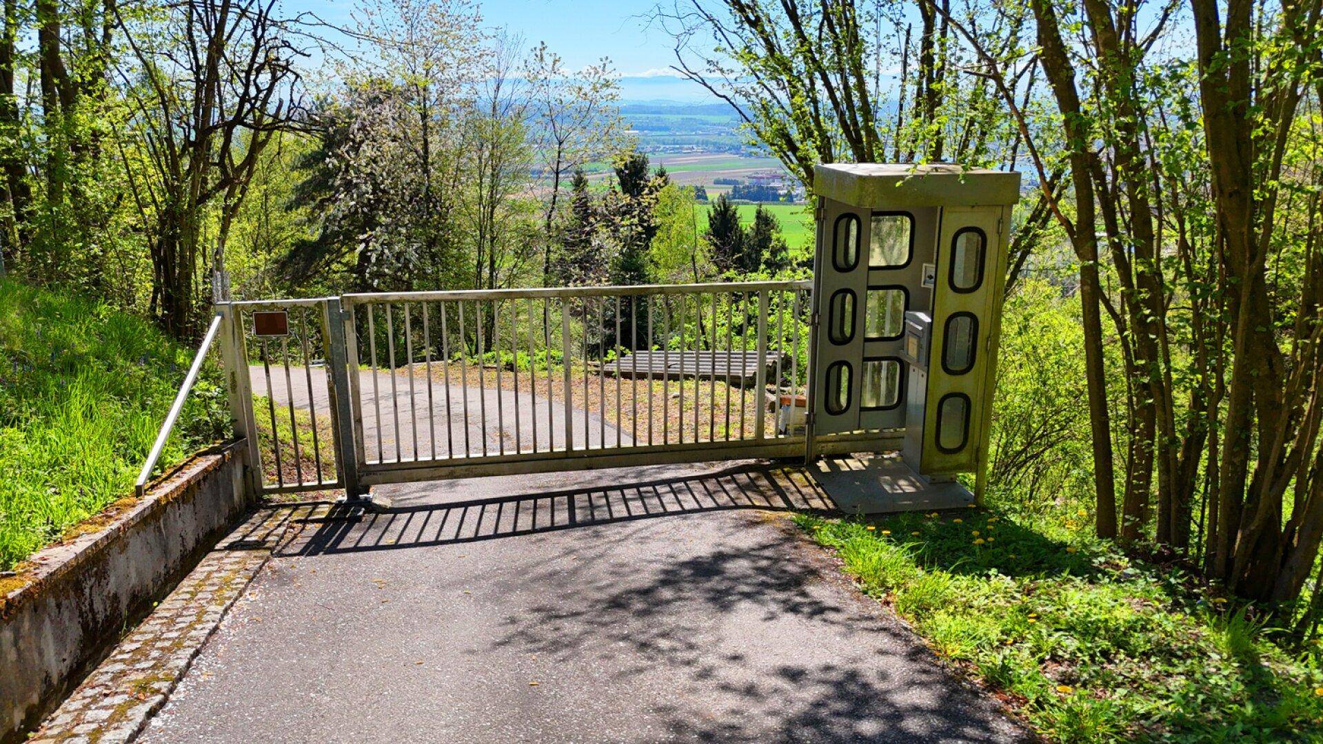 Eingangstor zur Liegenschaft mit Gegensprechanlage und weitem Blick in die Landschaft.