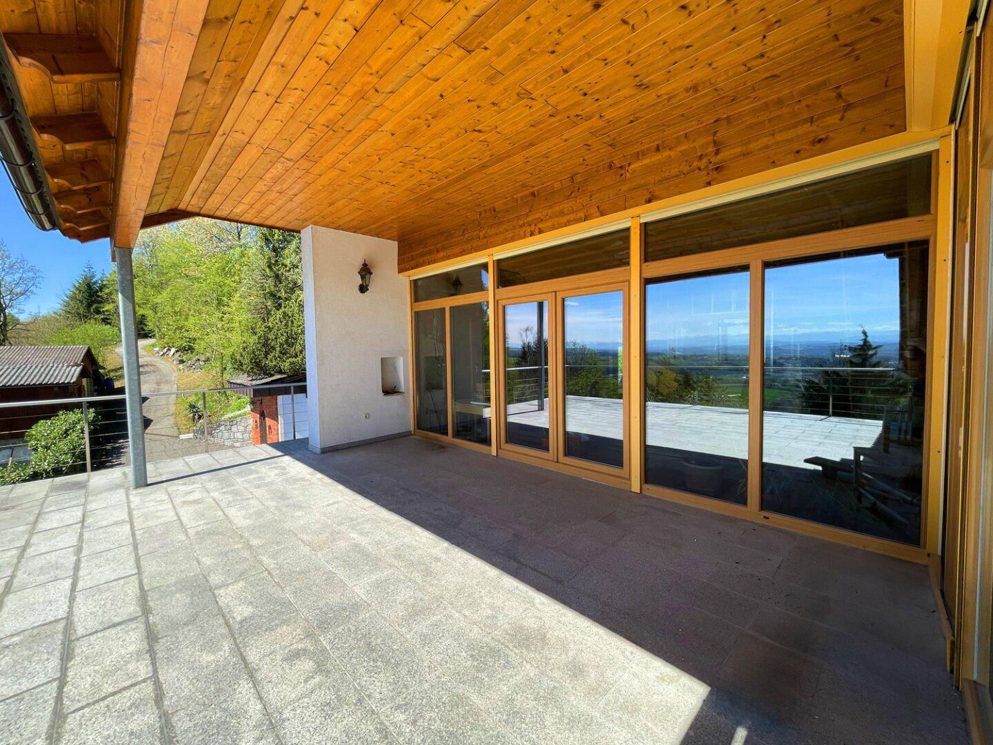 Sonniger Terrassenbereich mit robustem Steinboden und weitem Ausblick in die Landschaft.