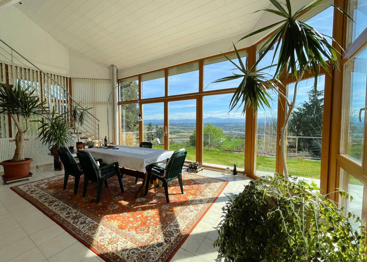 Geräumiges Esszimmer mit Panoramablick auf die umliegende Natur und die Alpen, ideal für gesellige Runden.