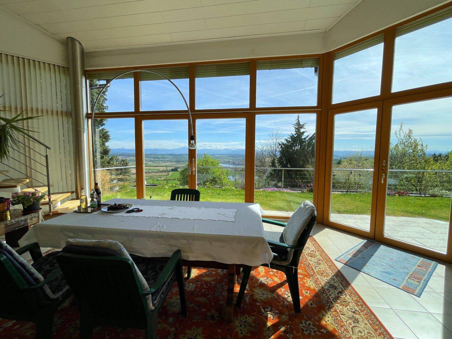 Heller Essbereich mit großen Fensterfronten, die einen malerischen Blick auf die weite Landschaft freigeben.