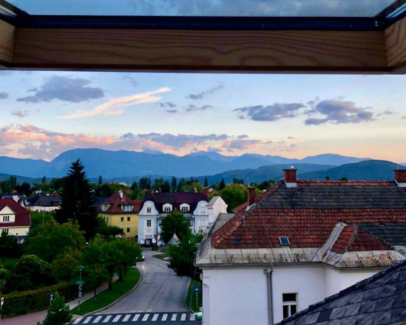 Malerischer Blick aus dem Fenster auf die umliegende Berglandschaft und eine ruhige Straße.