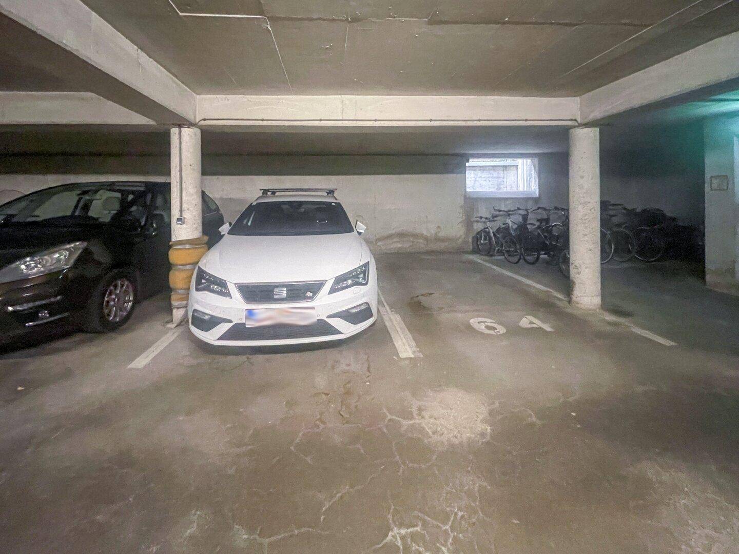 Tiefgarage mit Stellplätzen für Autos und einem separaten Bereich zur Fahrradaufbewahrung.