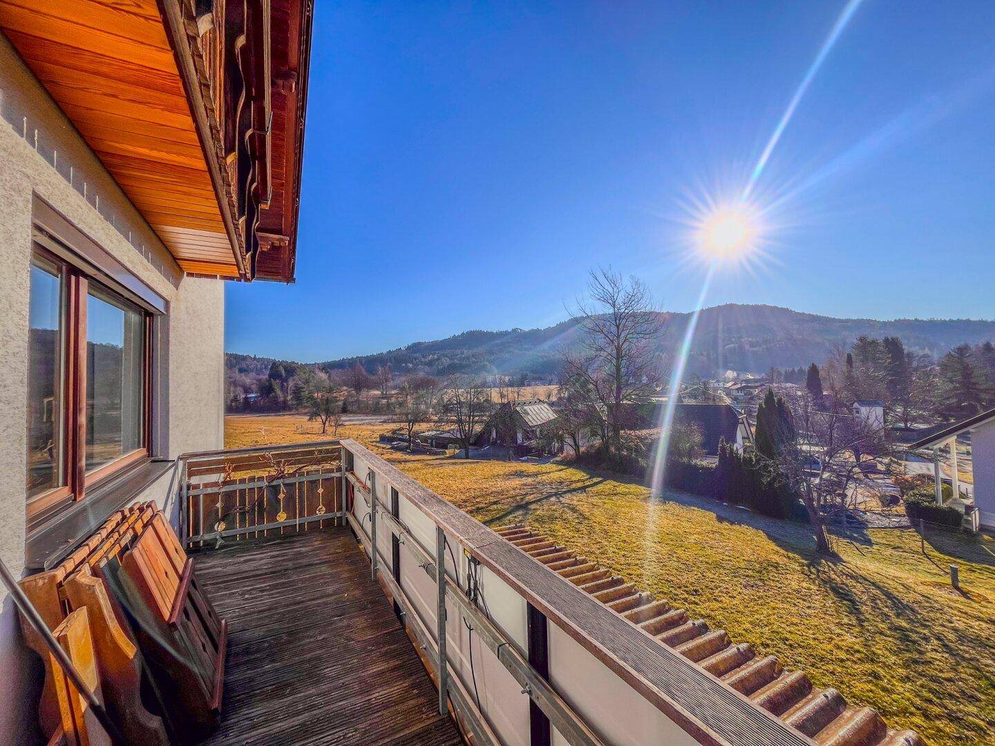 Sonniger Balkon mit Blick auf die hügelige Landschaft und den blauen Himmel.