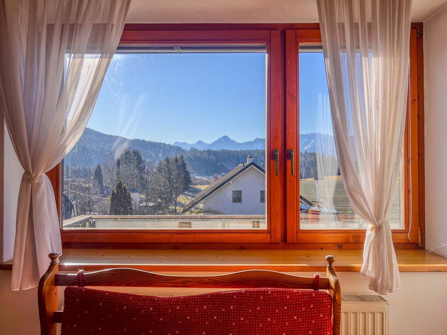 Schlafzimmer mit großem Fenster, das einen malerischen Blick auf die Berge und die Umgebung bietet.