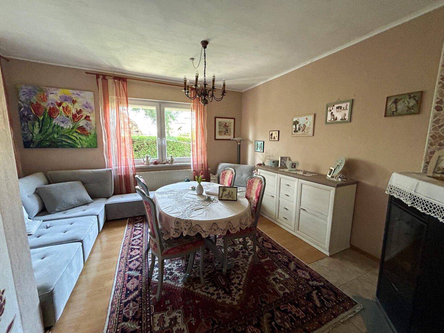Heller Wohn-Essbereich mit traditionellem Teppich, Esstisch und Sideboard.