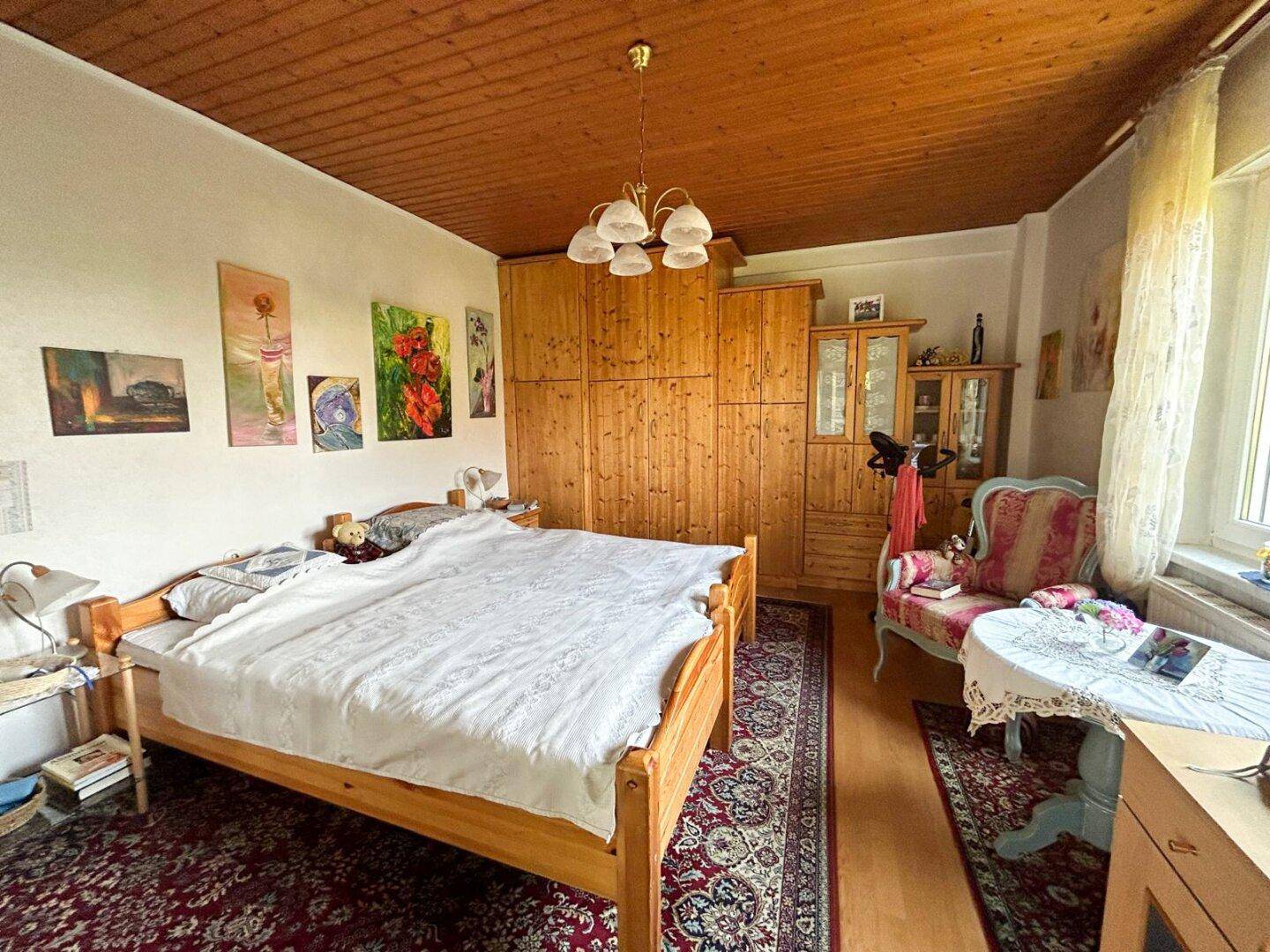 Geräumiges Schlafzimmer mit Doppelbett, Holzdecke und traditionellen Möbeln.