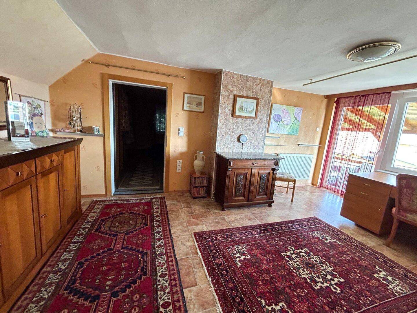 Helles Arbeitszimmer mit Schreibtisch, traditionellen Möbeln und Zugang zum Balkon.