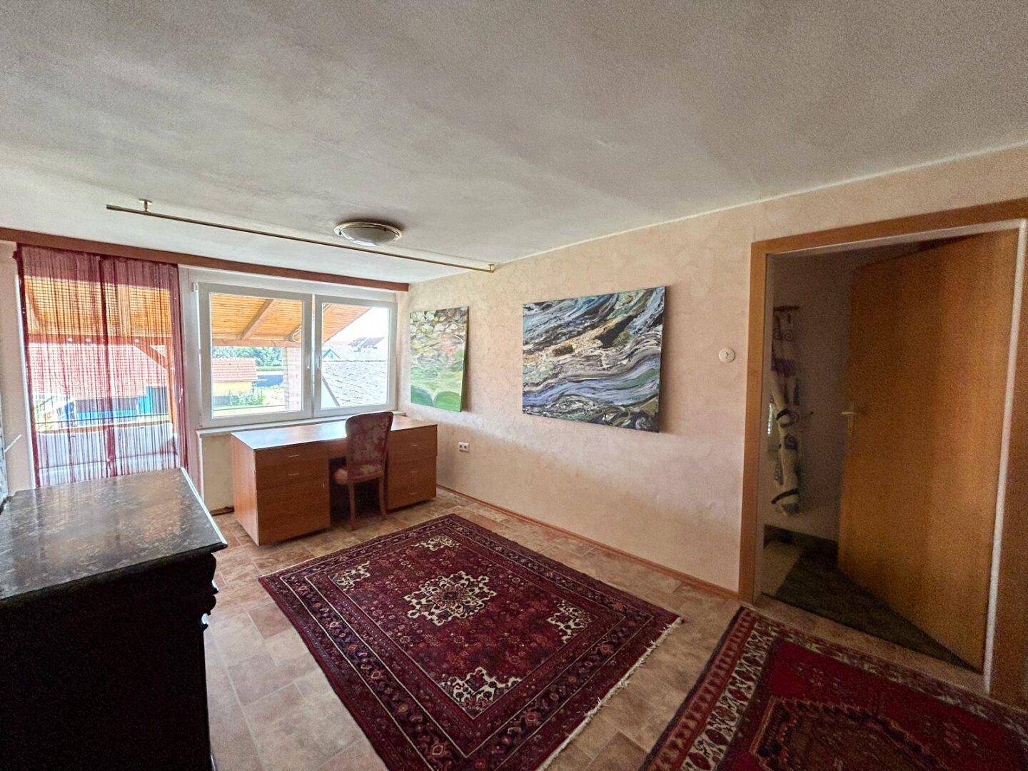 Arbeitszimmer mit Fenster, das viel Tageslicht hereinlässt, und traditioneller Einrichtung.