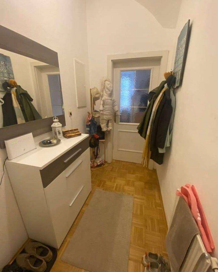 Heller Eingangsbereich mit Garderobe, Spiegel und praktischer Kommode für Stauraum.