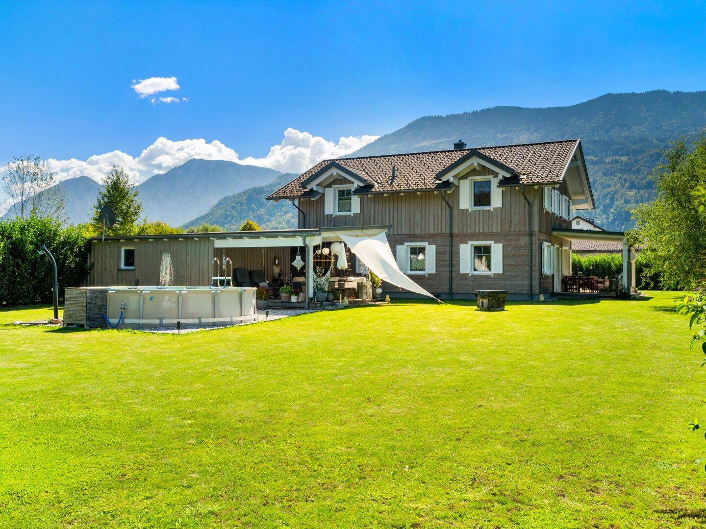 Charmantes Holzhaus mit großem Garten, Pool und beeindruckendem Bergblick.