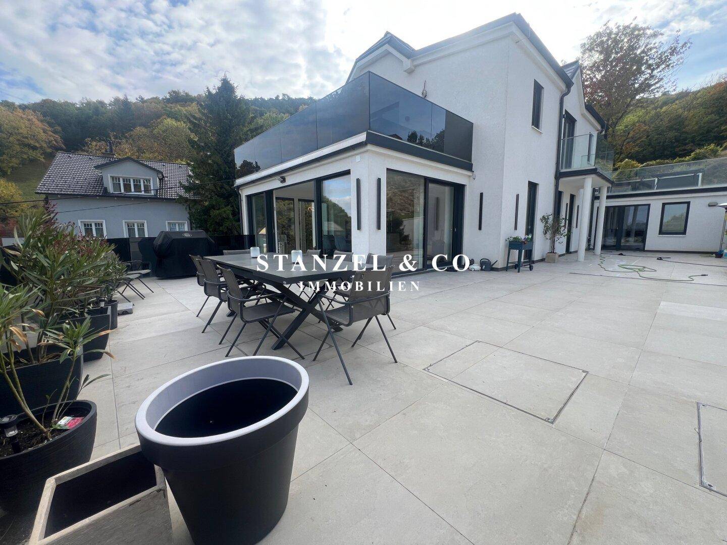Geräumige Terrasse mit modernem Esstisch und Stühlen, ideal für Mahlzeiten im Freien.