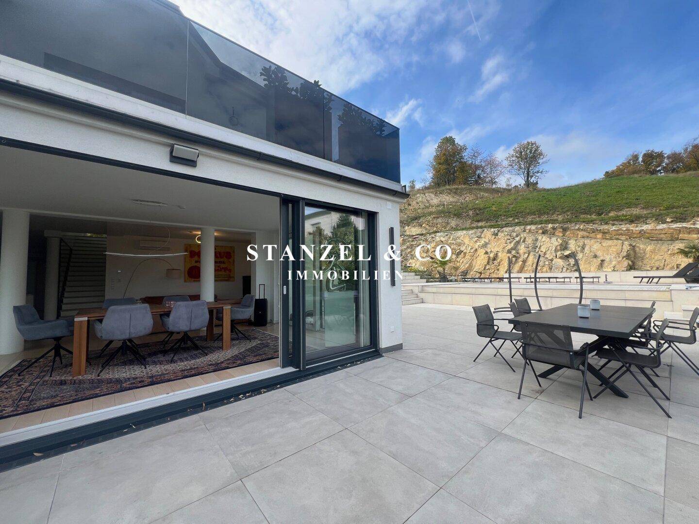 Heller Essbereich mit Holztisch und Stühlen, große Schiebetüren führen zur Terrasse.