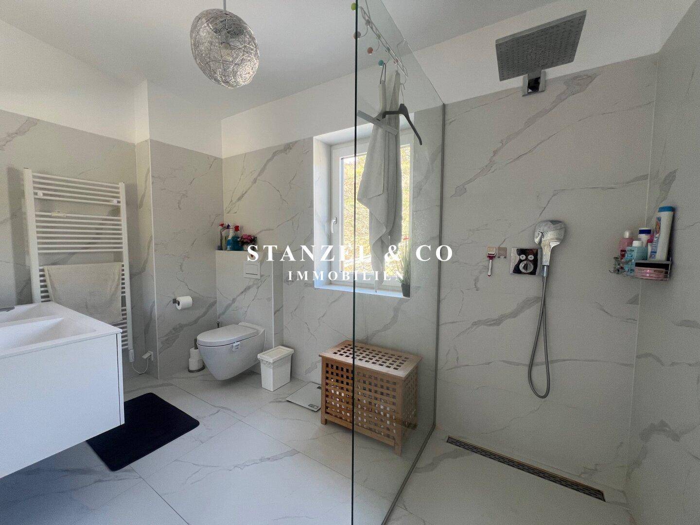 Luxuriöses Badezimmer mit freistehender Badewanne, begehbarer Dusche und Marmorfliesen.