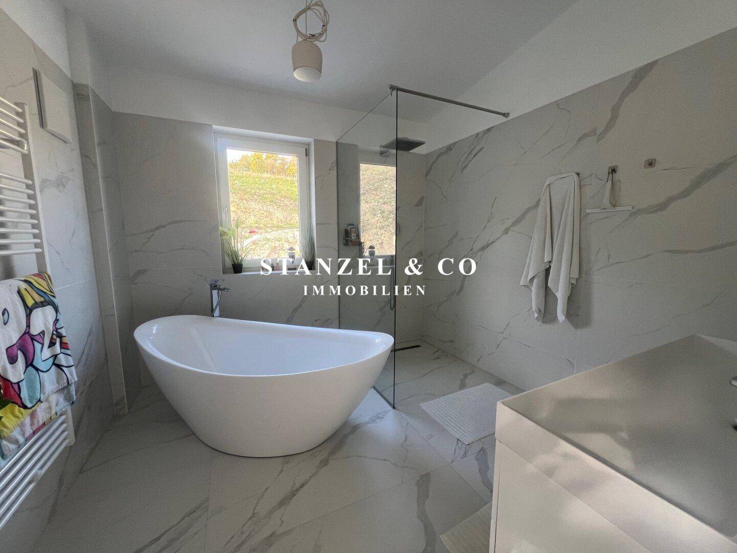 Modernes Badezimmer mit begehbarer Dusche, Waschtisch und Fenster.