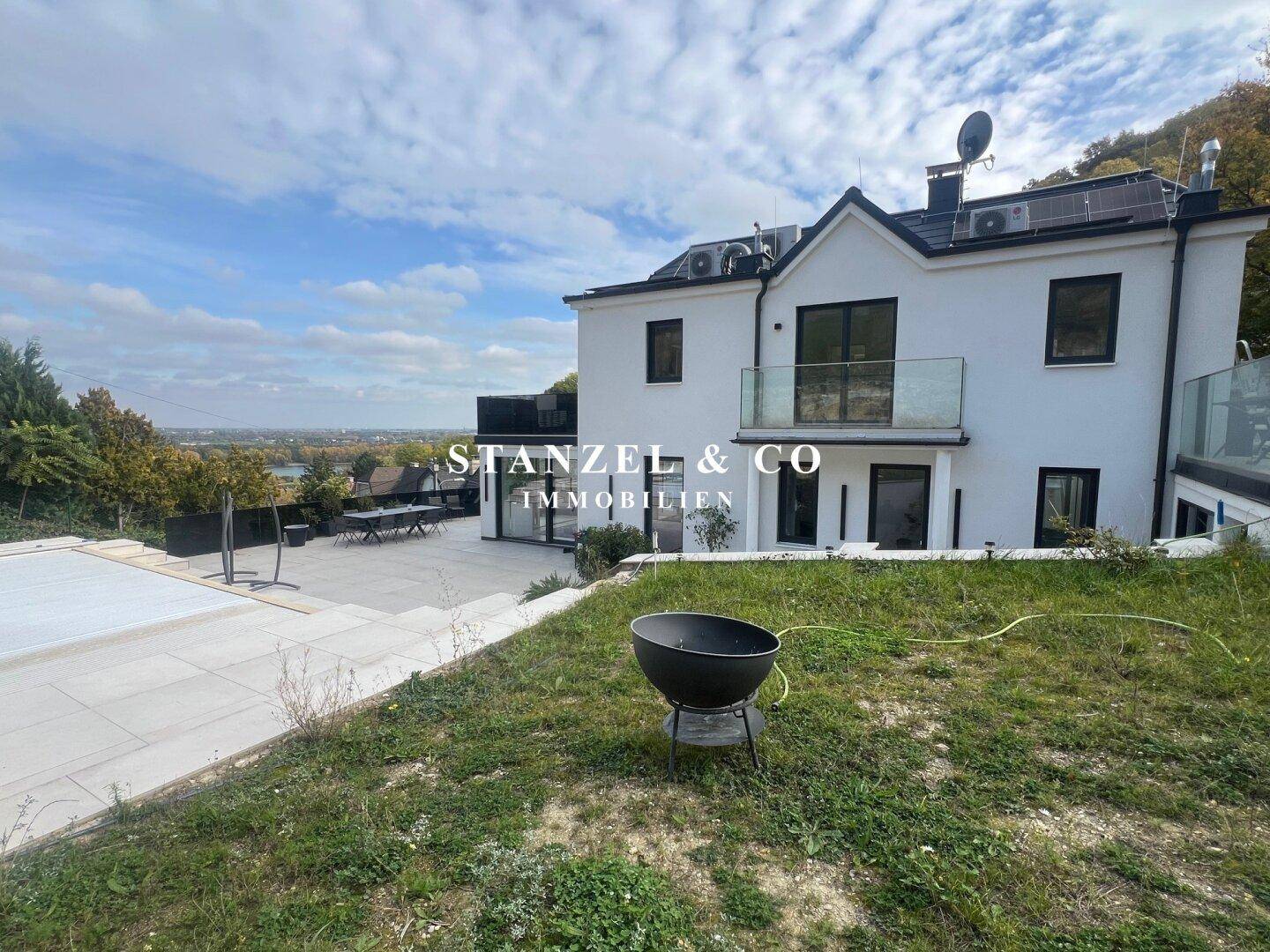 Moderne Villa mit Pool und weitem Blick über die Landschaft und die Stadt.