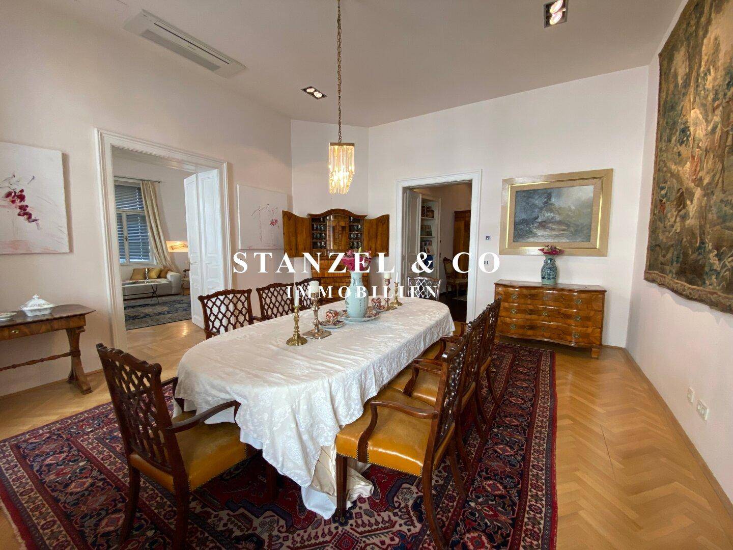 Geräumiges Esszimmer mit klassischem Mobiliar, Parkettboden und Blick in den Wohnbereich.