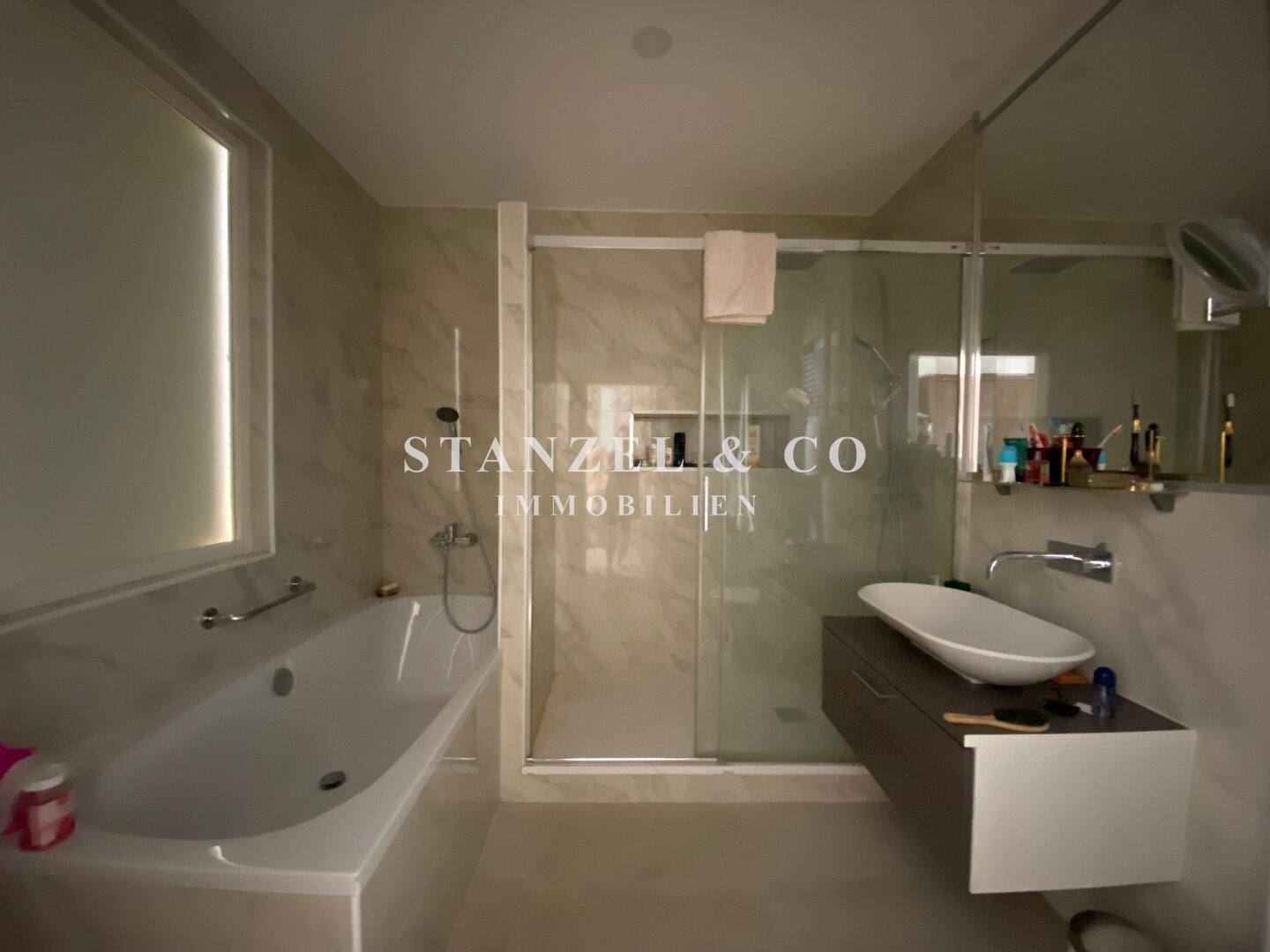 Modernes Badezimmer mit Badewanne, Dusche und elegantem Waschbecken.