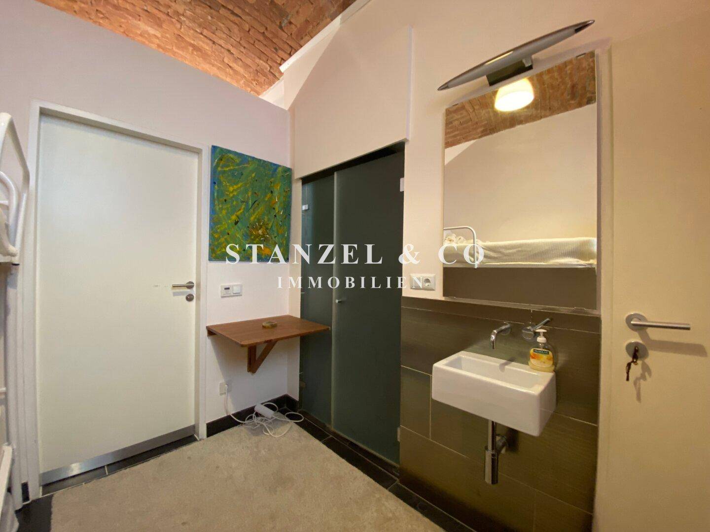 Einfaches Zimmer mit Etagenbett, Waschbecken und gewölbter Ziegeldecke.