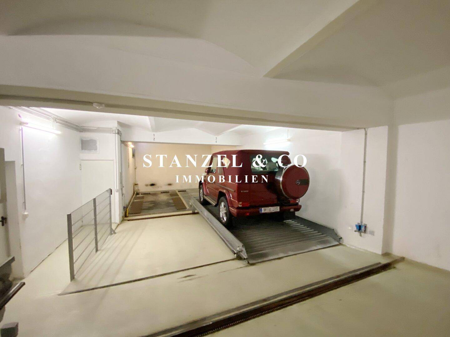 Tiefgarage mit Autolift und ausreichend Platz für Fahrzeuge.