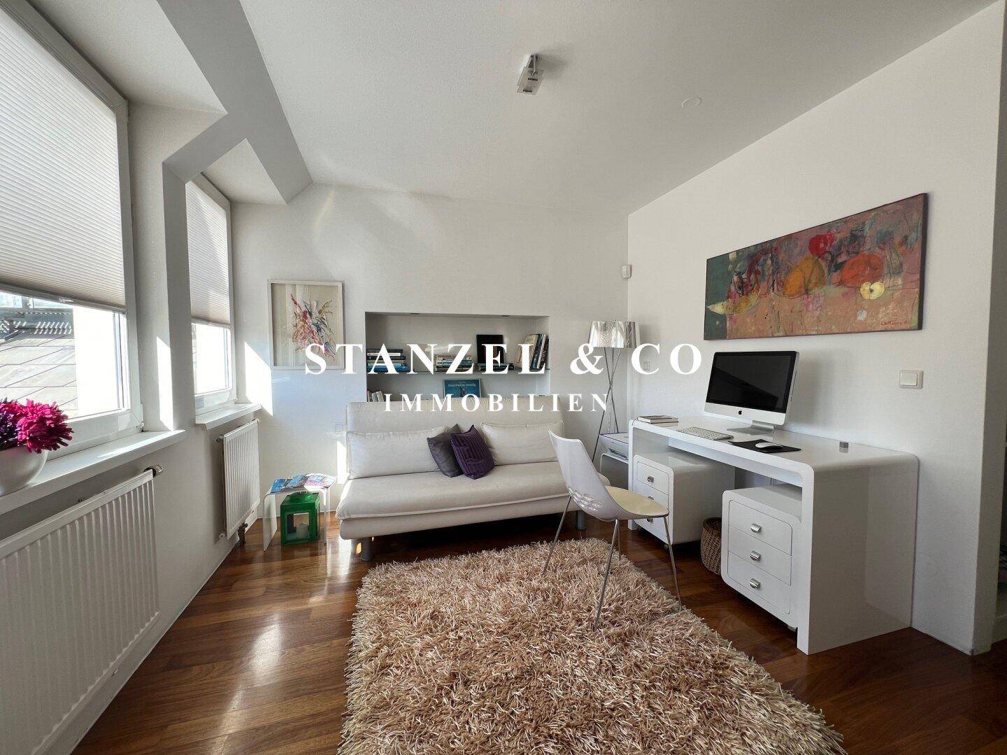 Gemütliches Schlafzimmer mit Holzboden, Bett und Schreibtisch, bietet viel Tageslicht.