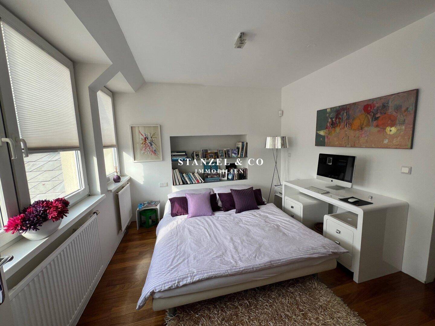 Helles Schlafzimmer mit Holzboden, Bett und Schreibtisch, ideal für Ruhe und Arbeit.