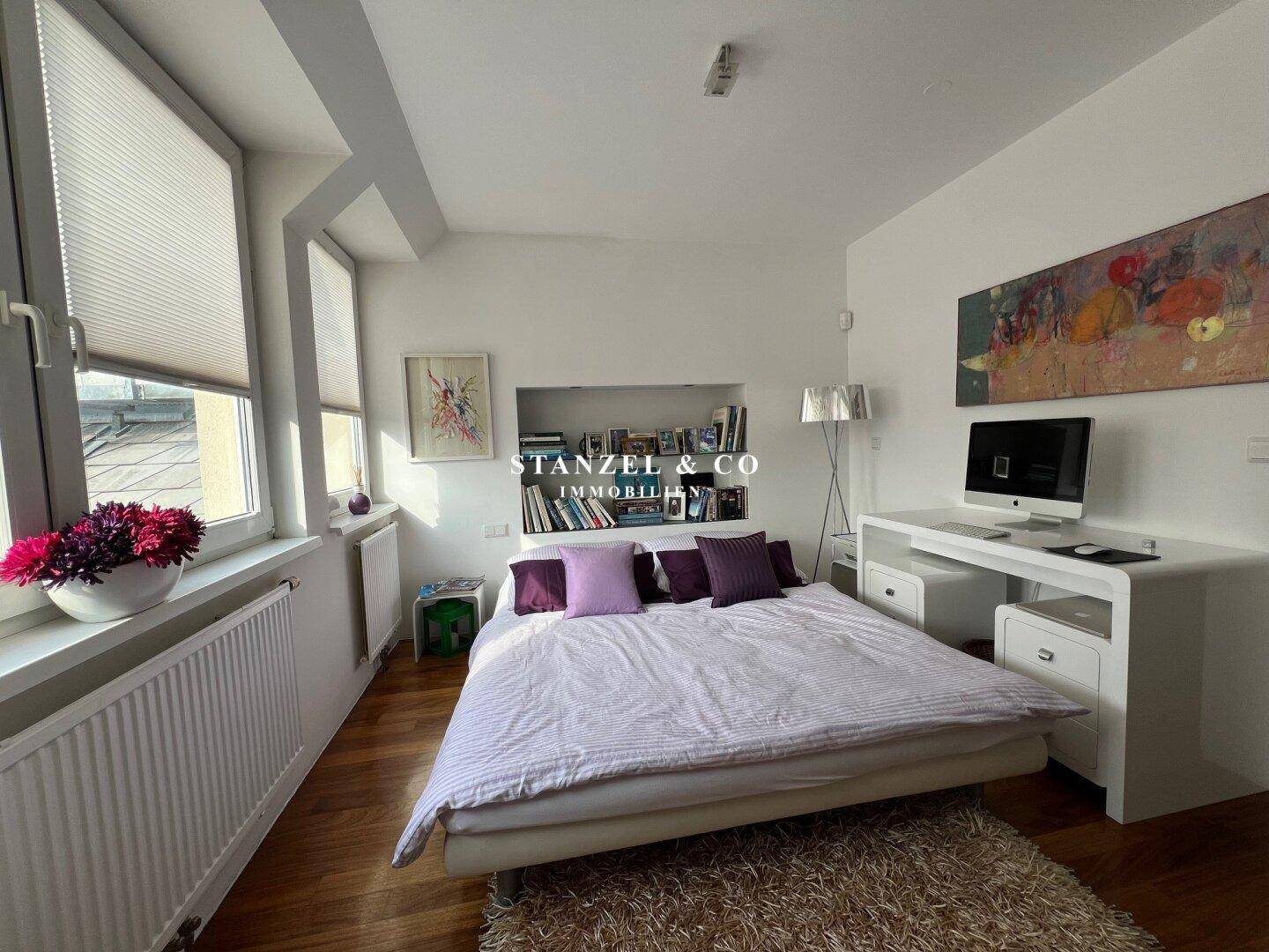 Helles Arbeitszimmer mit Holzboden, Schreibtisch und Sofa, bietet eine angenehme Arbeitsatmosphäre.