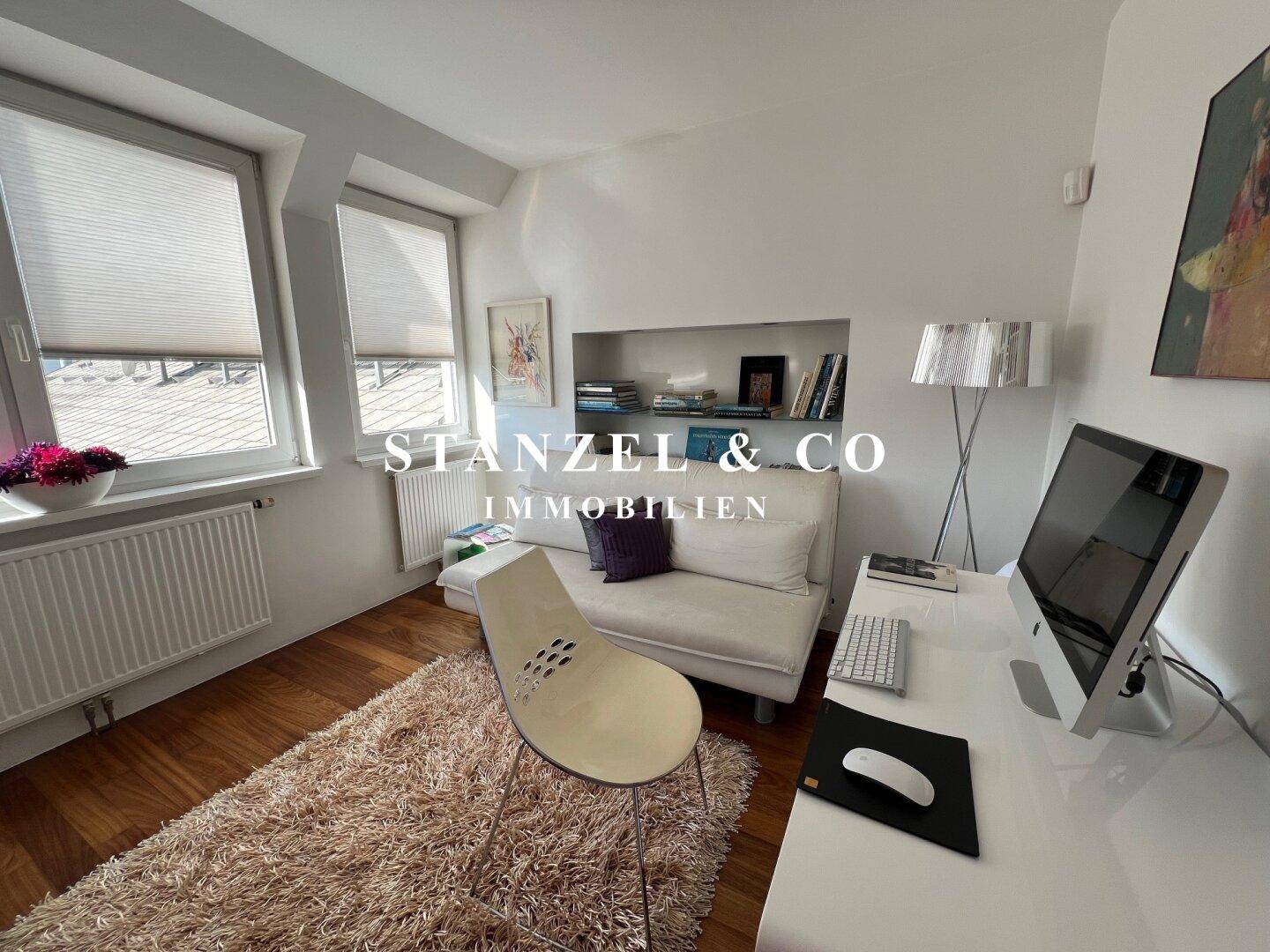 Arbeitszimmer mit Holzboden, Schreibtisch und Bücherregal, bietet viel Stauraum.
