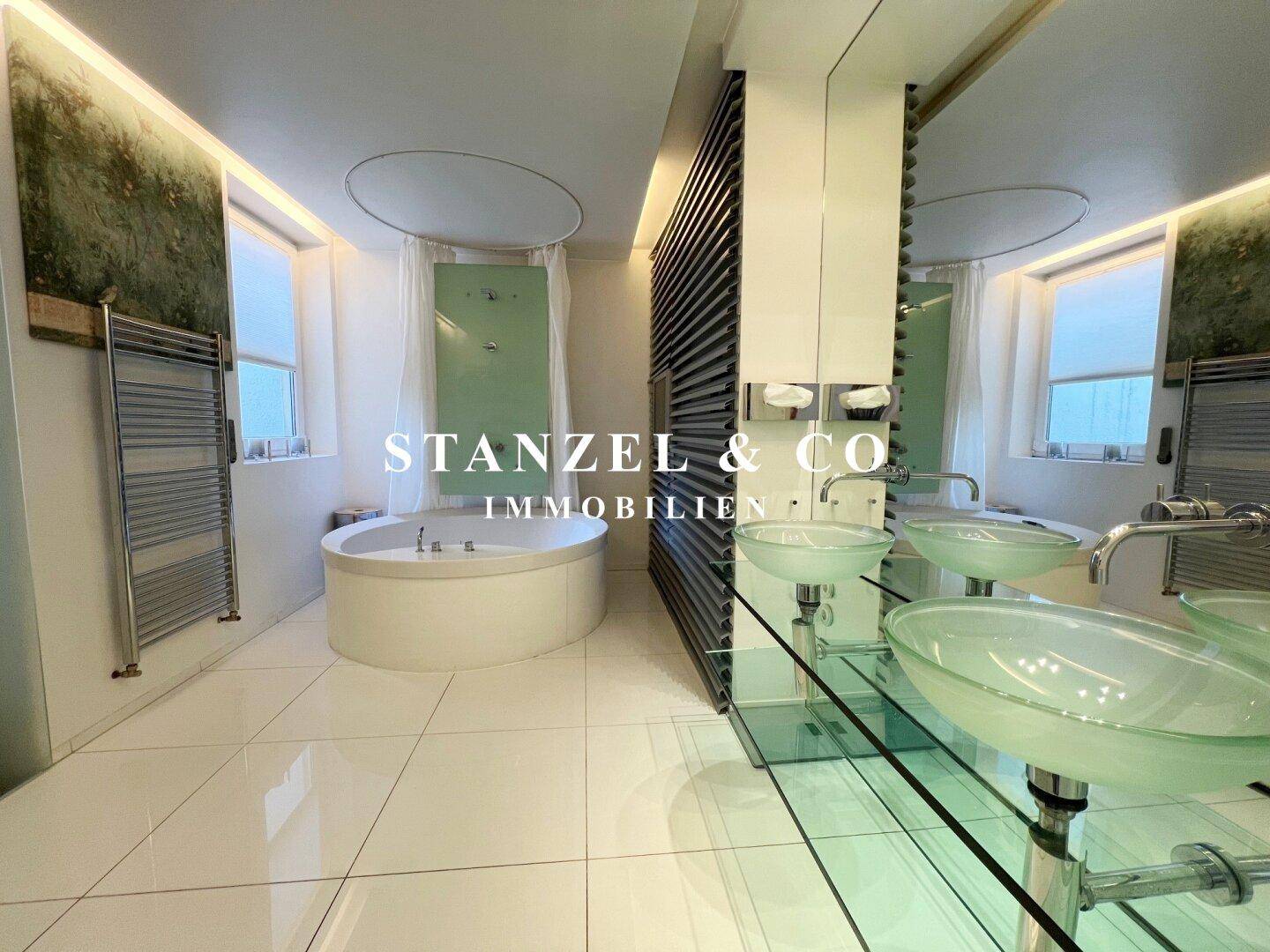 Modernes Badezimmer mit runder Badewanne und viel Stauraum für Handtücher und Accessoires.