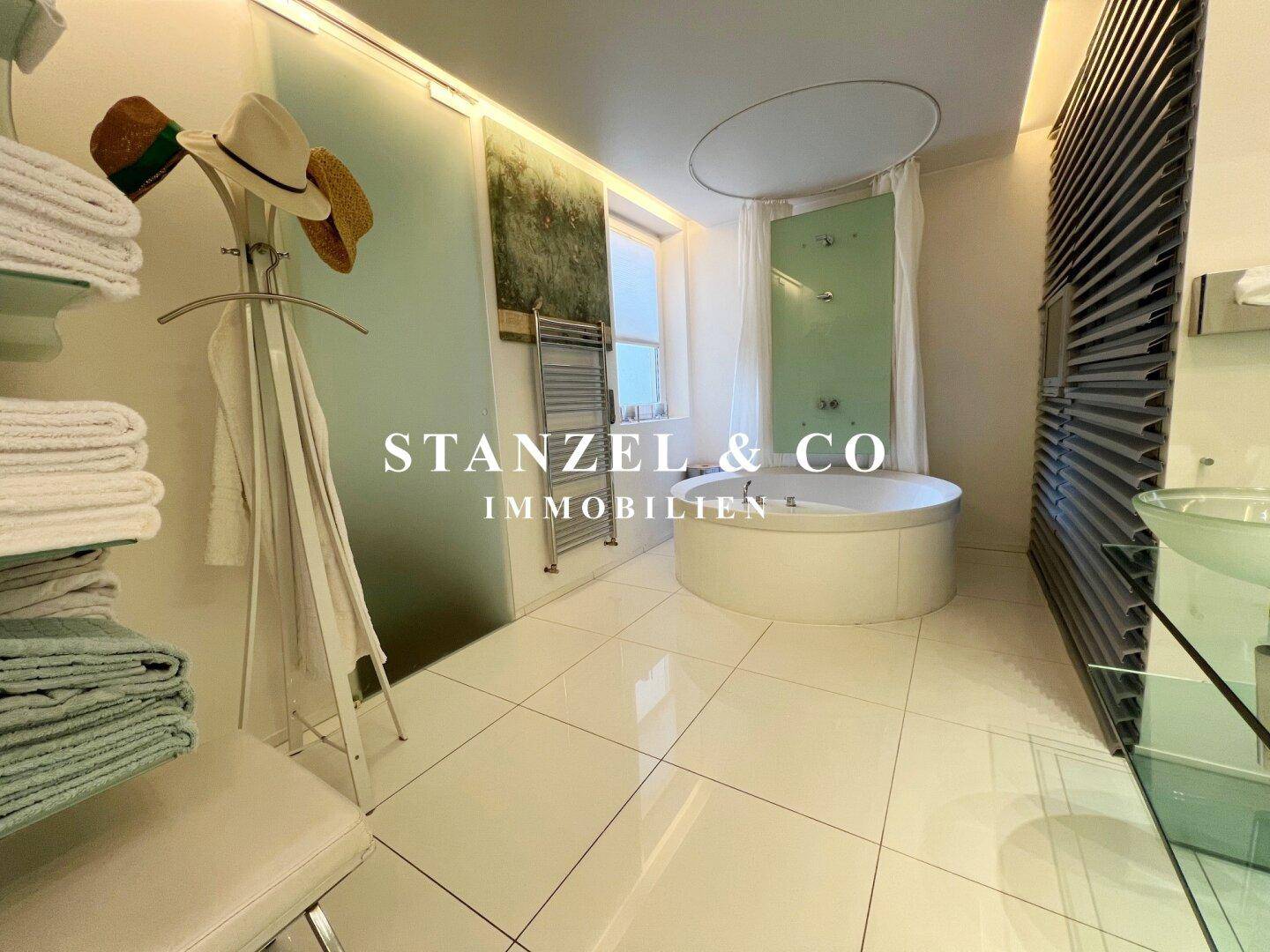 Modernes Badezimmer mit Glasregalen und viel Stauraum, bietet eine luxuriöse Atmosphäre.