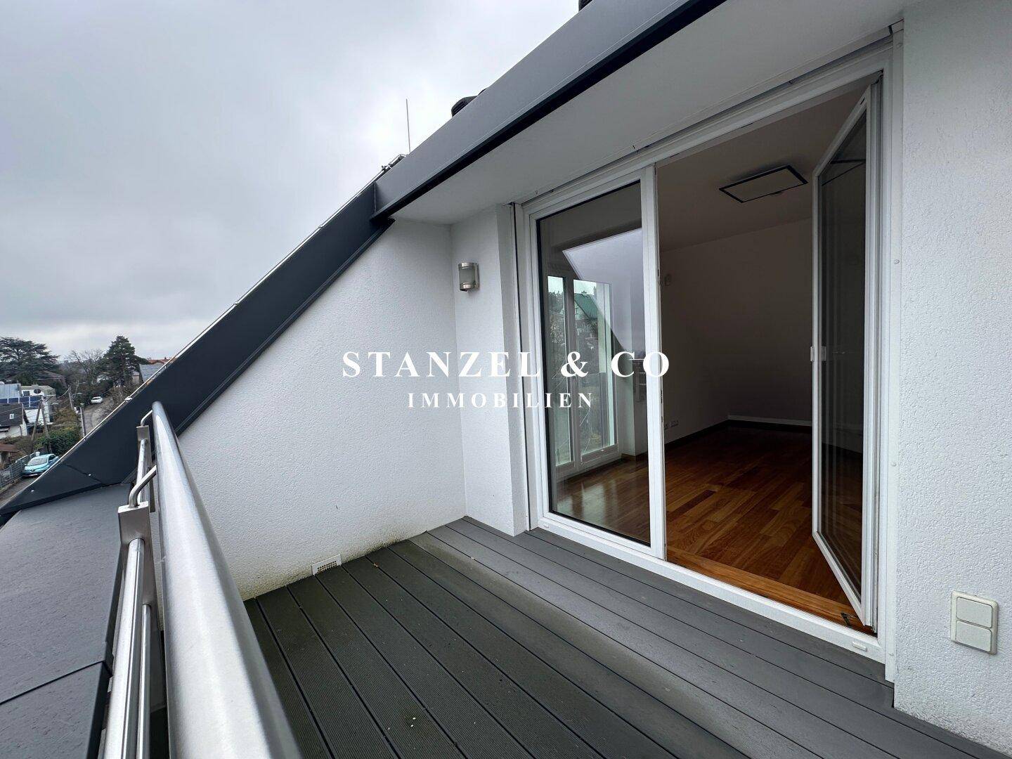 Kleiner Balkon mit modernem Geländer und Blick auf die Umgebung.