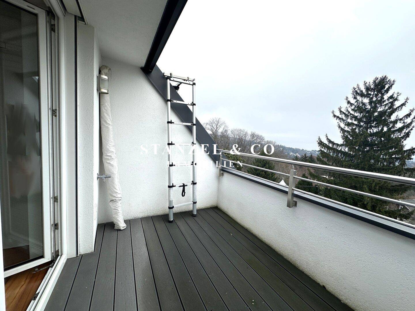 Balkon mit Holzplankenboden und Blick auf die umliegende Landschaft.