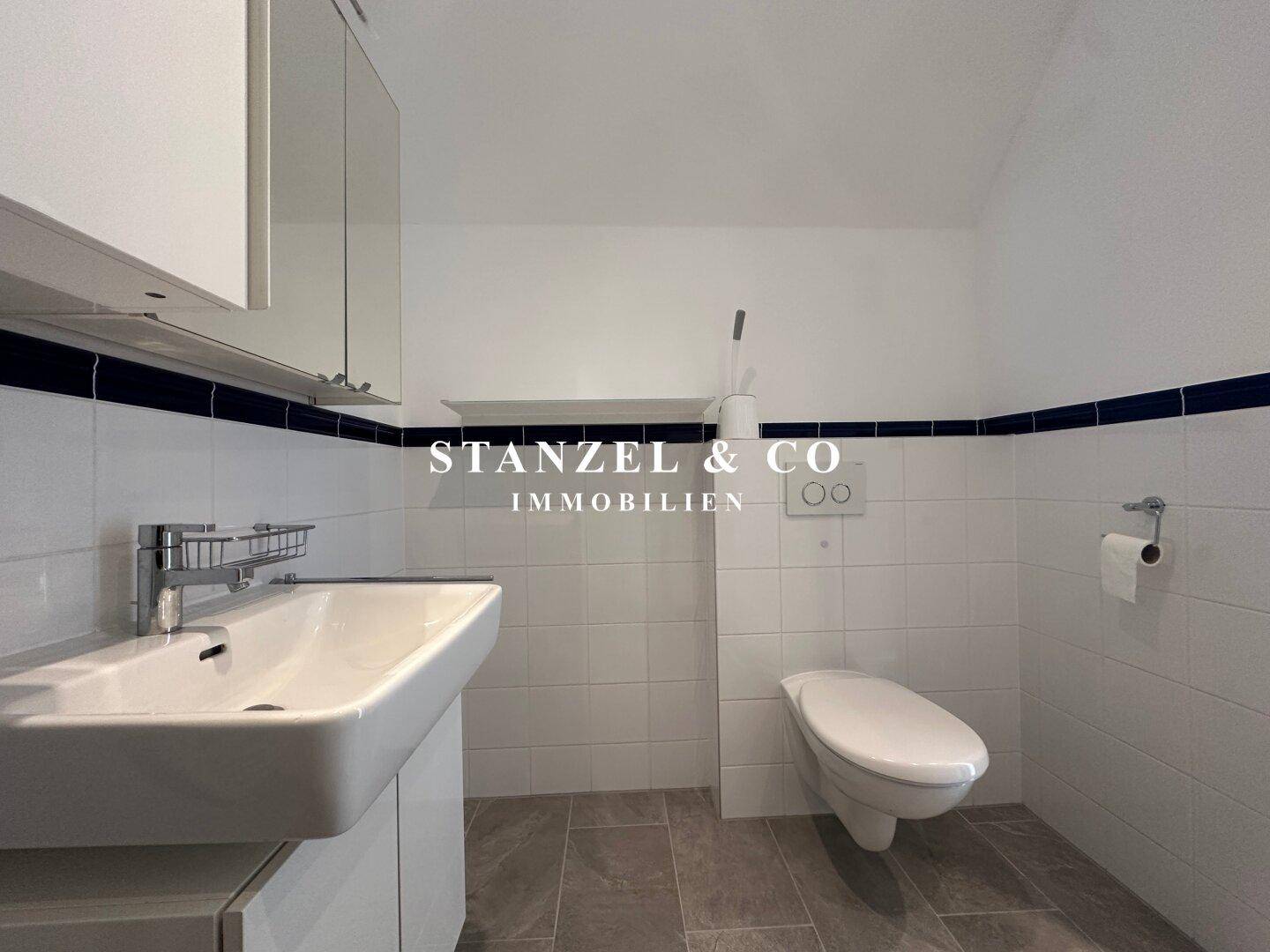 Separate Toilette mit Waschbecken und Wand-WC, ideal für Gäste.