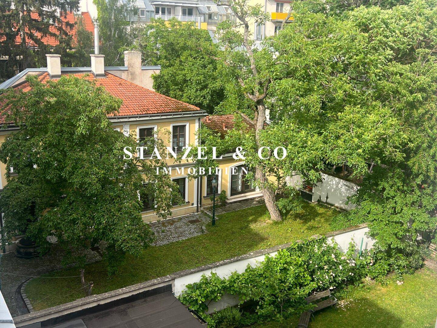 Weitläufiger Gartenbereich mit altem Baumbestand und einem charmanten Haus im Grünen.