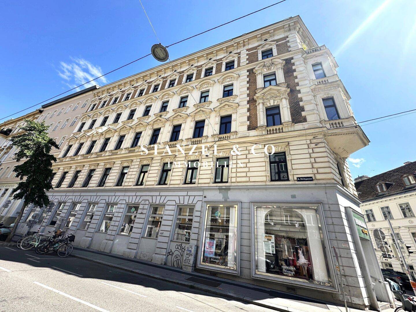 Detailansicht der historischen Fassade mit Geschäften im Erdgeschoss und Wohnungen darüber.