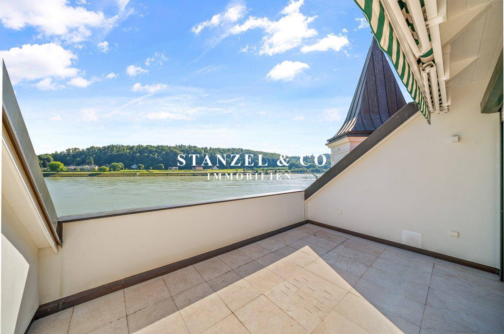 Geräumiger Balkon mit Fliesenboden und Panoramablick auf den Fluss und die umliegende Natur.
