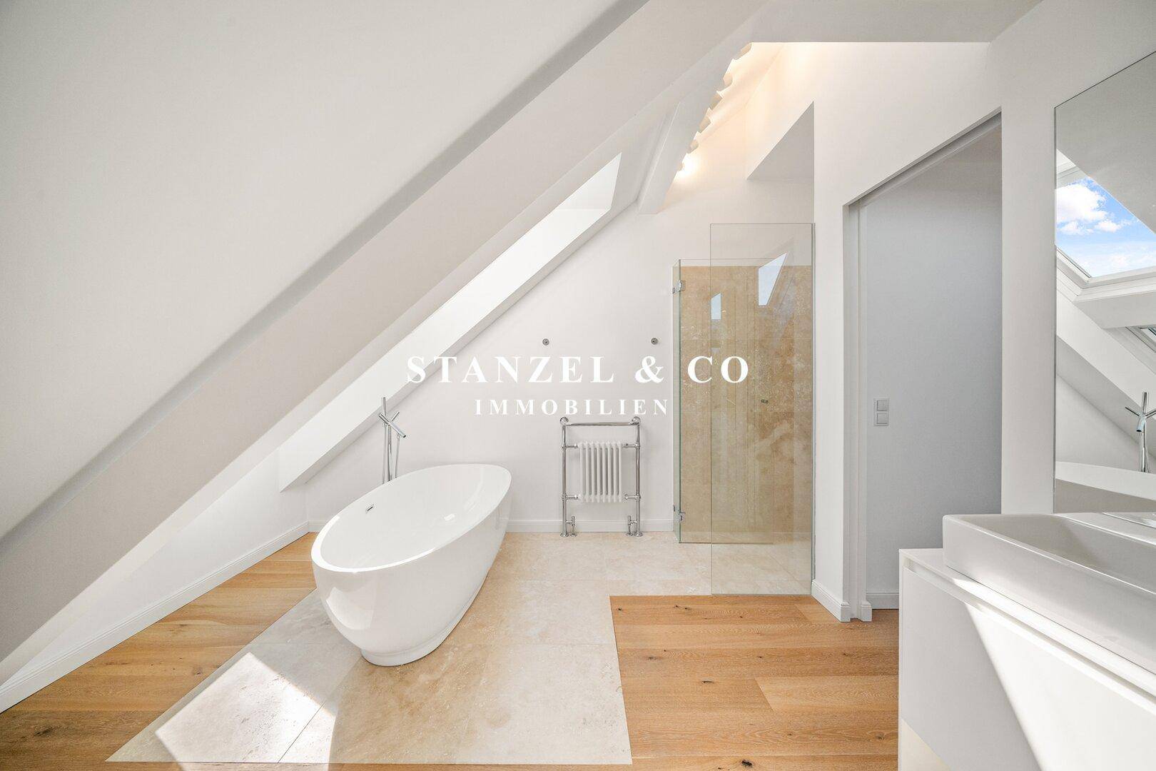 Modernes Badezimmer im Dachgeschoss mit freistehender Badewanne, Dusche und Holzboden.