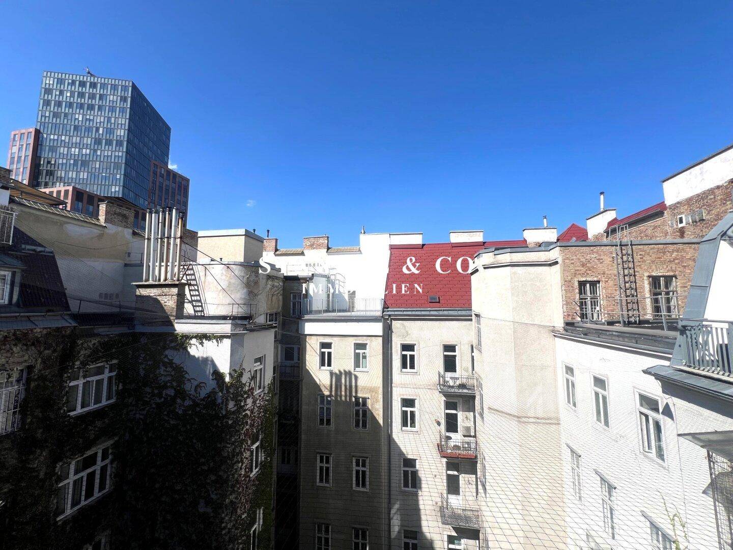Blick auf die vielfältige Architektur der umliegenden Gebäude und einen modernen Hochhausbau.