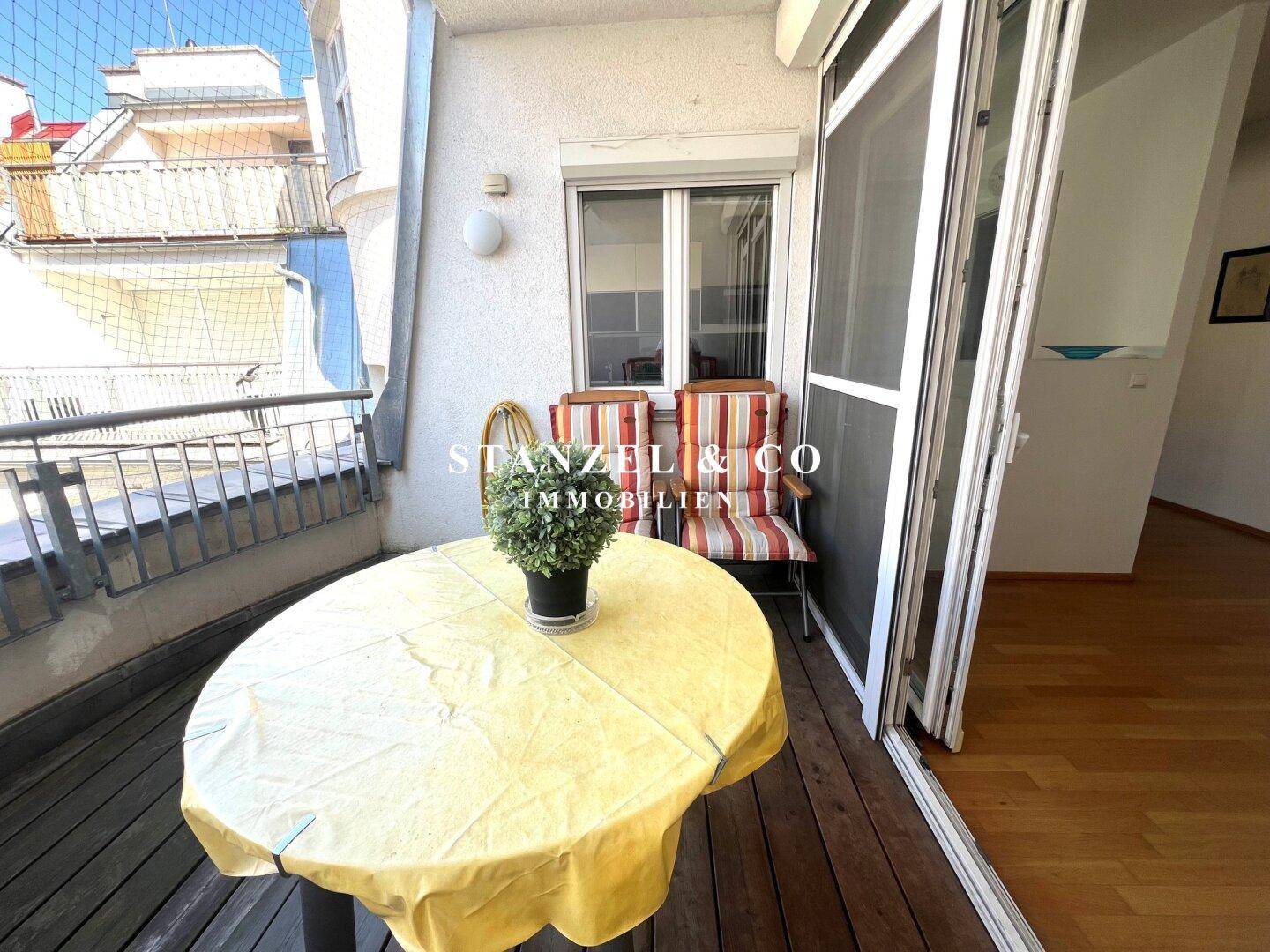 Gemütlicher Balkon mit kleinem Tisch und Stühlen, ideal für entspannte Stunden im Freien.