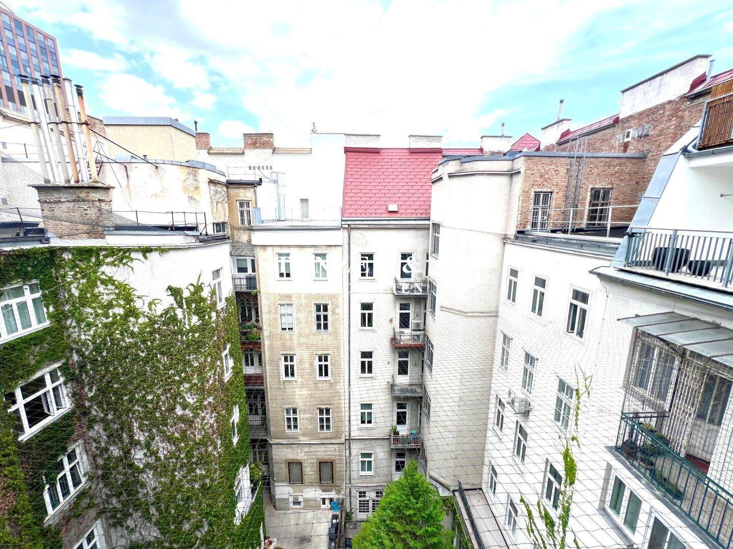 Blick in den Innenhof mit begrünten Fassaden und traditionellen Gebäuden.