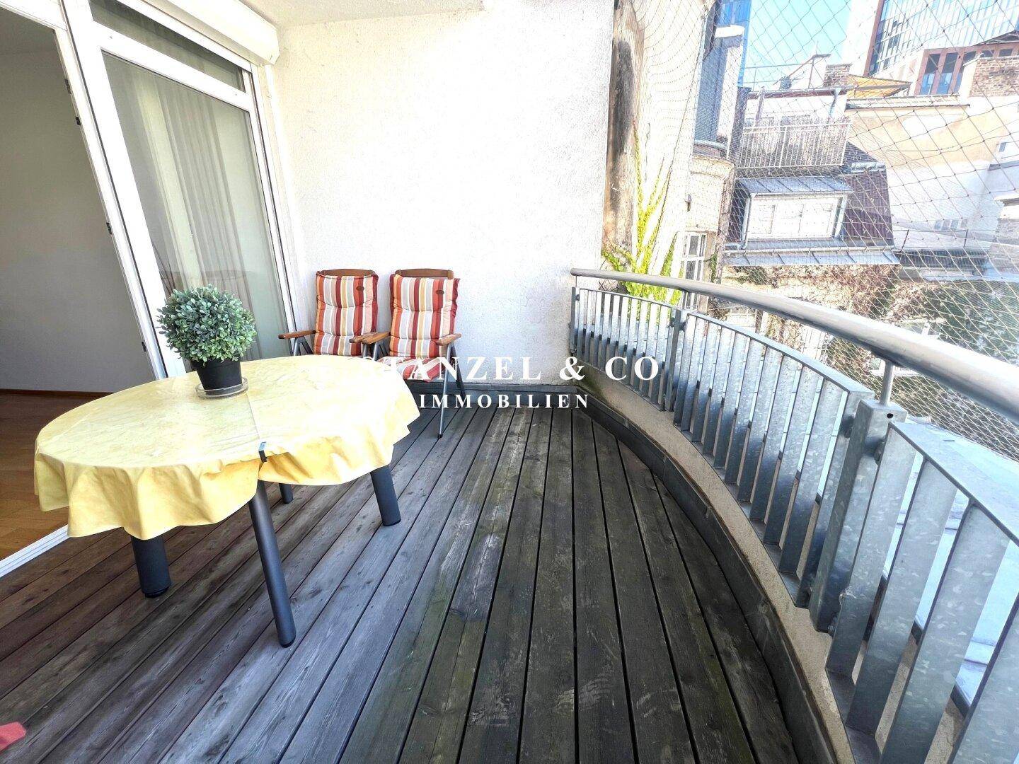 Geschwungener Balkon mit robustem Holzboden und Metallgeländer, bietet einen schönen Außenbereich.