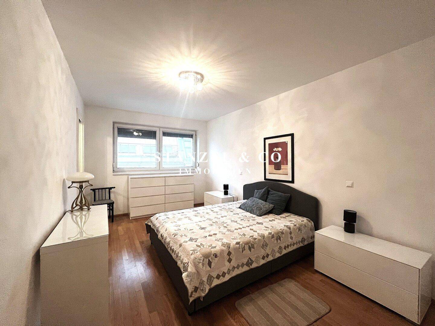 Gemütliches Schlafzimmer mit Doppelbett, Kommoden und Fenster für natürliches Licht.